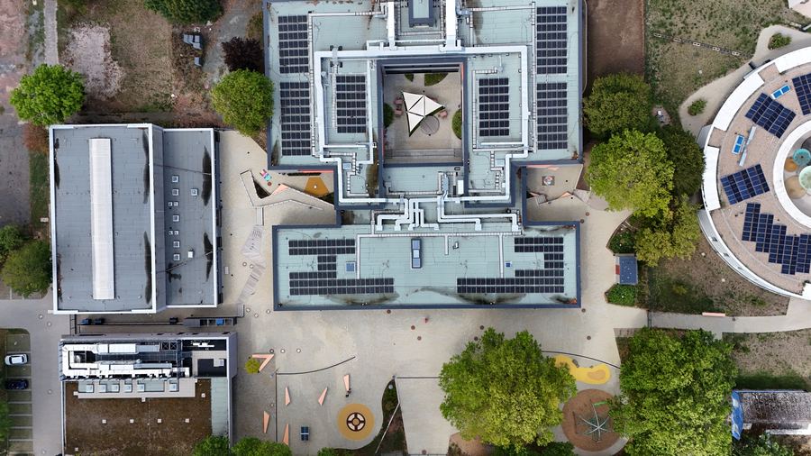 Senkrechte Aufnahme der D&auml;cher mit Photovoltaikmodulen und dem Innenhof in der Mitte
