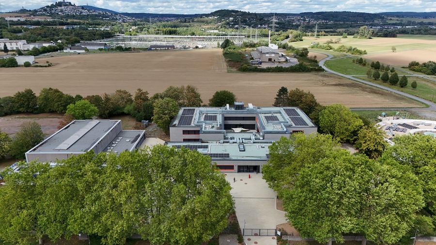 Blick &uuml;ber die Schule hinweg auf Felder, Wiesen und die H&uuml;gel am Horizont